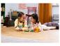 Deux filles jouent avec des ensembles LEGO Animal Crossing sur un parquet.