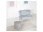 Fauteuil bleu clair et pouf gris en forme de cœur sur un sol blanc avec un tapis.