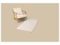 Fauteuil en bois avec coussins crème et tapis crème à motif géométrique.