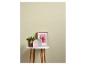 Plante verte, décorations de maison roses et grises, et cadre photo de fleur sur table blanche.