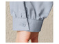 Gros plan sur une chemise bleu clair avec un bouton.