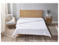 Une couette blanche sur un lit en bois avec une table de chevet et une chaise.