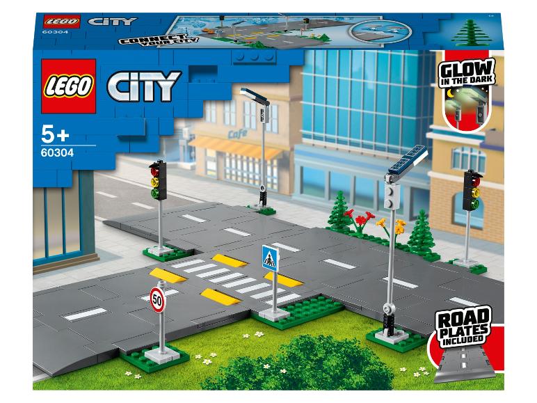 LEGO City : panneaux routiers, feux et lampadaires lumineux dans le noir.