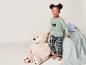 Une petite fille en pyjama avec l'inscription 'Follow your dreams' et un ours en peluche.