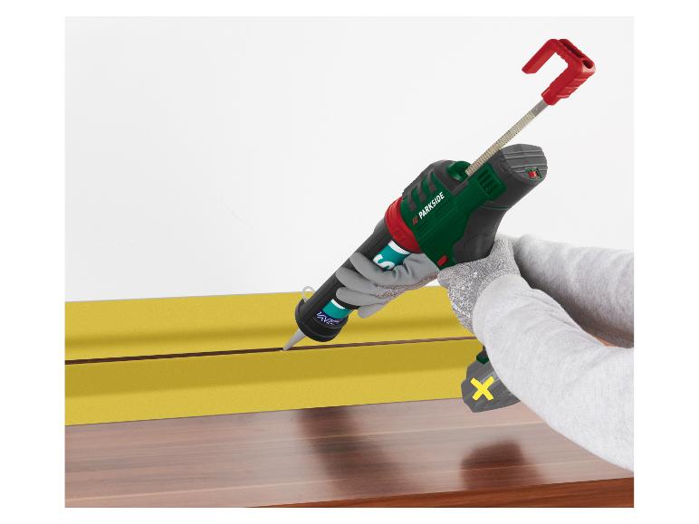 Pistolet à calfeutrer sans fil Parkside utilisé pour appliquer du mastic sur une surface jaune.