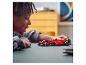 Un enfant joue avec une voiture de course LEGO Ferrari de Formule 1.