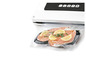 Une machine à emballer sous vide avec du saumon et du citron dans un sac sous vide.