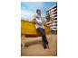 Homme en t-shirt rayé et pantalon bleu, appuyé sur un bateau jaune sur la plage.