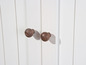 Deux boutons en bois sur des portes blanches.