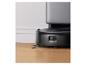 Robot aspirateur noir avec station de charge sur un parquet.