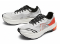 Paire de chaussures de course blanches et noires avec des accents orange.