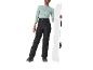 Femme en haut menthe, pantalon de snowboard noir et snowboard.