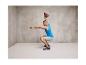 Un homme fait des squats avec une kettlebell dans une salle de sport.