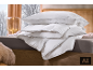 Couette et oreiller blancs avec passepoil gris sur un lit
