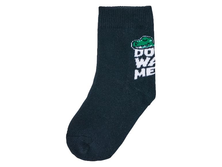 Une chaussette bleu foncé avec un crocodile et l'inscription 'Don't waste me'