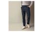Un homme portant un pantalon bleu marine avec un cordon et des baskets blanches.