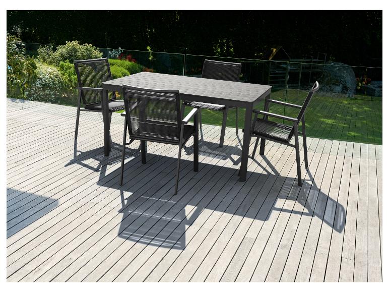 Une table à manger noire avec quatre chaises assorties sur une terrasse en bois.