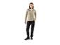 Une femme porte un pull beige et un pantalon de travail noir.