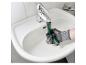 Une personne gantée utilise un outil de plomberie multifonctionnel sur un robinet de lavabo.