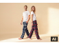 Homme et femme en t-shirts blancs et pantalons de pyjama à carreaux, souriants.