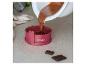 Pâte à chocolat versée dans un moule Coox rose.
