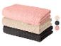 Pile de serviettes de bain pliées en rose, beige et gris foncé