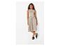 Femme en robe midi beige sans manches et sandales noires, posant sur fond blanc.