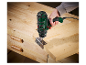 Une personne utilise une perceuse Parkside pour fixer une charnière sur une planche de bois.
