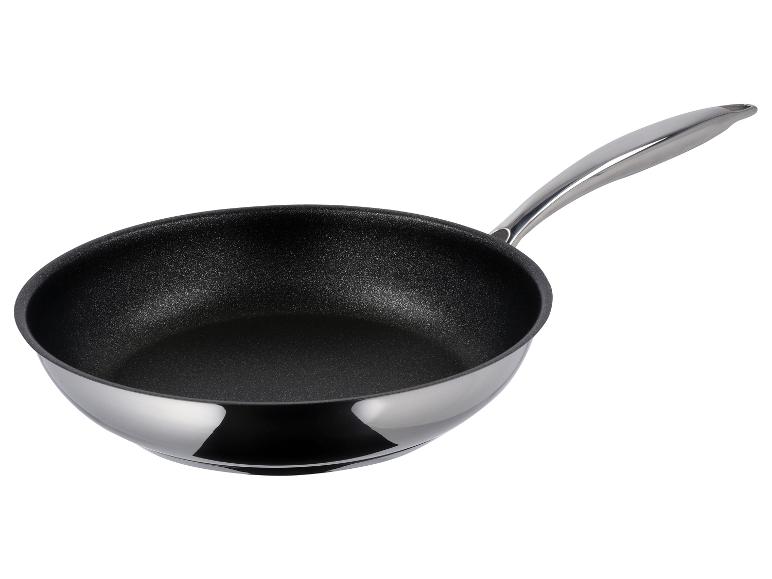 Une poêle à frire argentée brillante avec un revêtement antiadhésif noir et une poignée assortie.