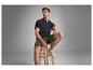 Un mannequin masculin porte un polo bleu marine et un short olive.