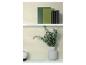 Livres et vase avec des branches d'eucalyptus sur des étagères blanches contre un mur texturé.