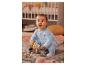 Un bébé en combinaison bleue joue avec des jouets en bois.