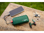 Batterie externe verte chargeant un smartphone, avec des clés et un porte-clés mini-perceuse.