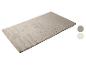 Un tapis doux et rectangulaire de couleur beige clair avec deux échantillons de couleur à côté.