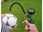Manomètre numérique gonflant un ballon de football sur fond d'herbe.