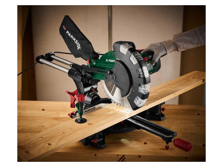 Une personne coupe une planche de bois avec une scie circulaire sur un établi en bois.