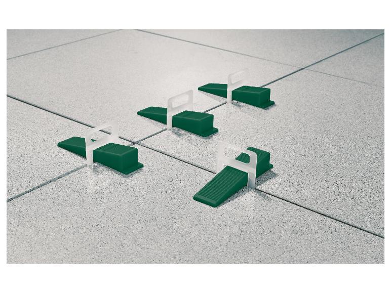 Système de nivellement de carreaux avec cales vertes et clips blancs sur carrelage gris