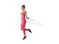 Femme en tenue de sport rose sautant à la corde