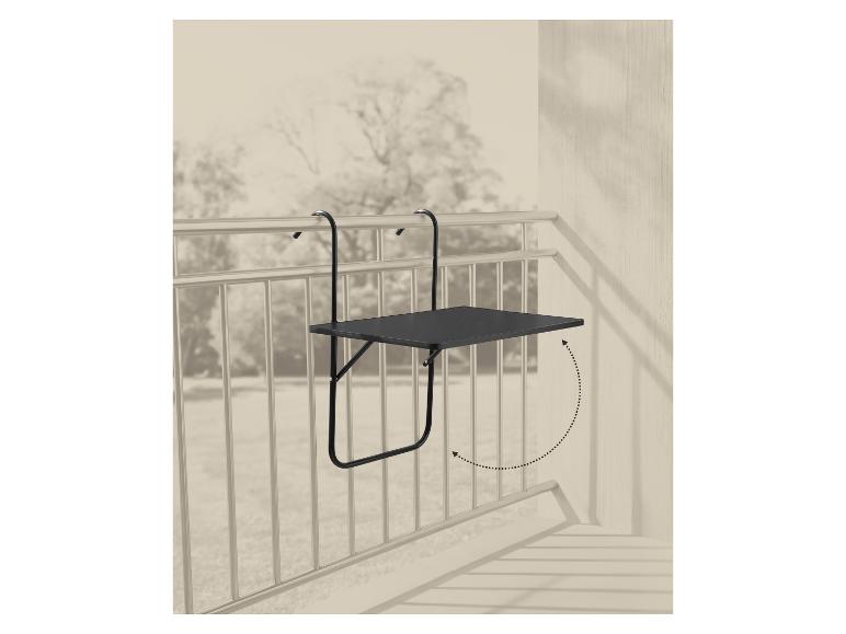 Table de balcon pliable noire accrochée à une balustrade, avec une flèche pointillée indiquant qu'elle peut se replier.