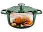 Marmite en fonte verte avec une coupe transversale montrant un poulet rôti à l'intérieur.