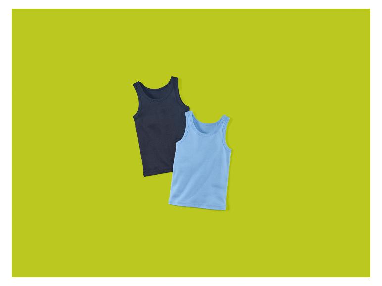 Deux débardeurs pour enfants, un bleu foncé et un bleu clair, sur fond vert.