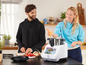 Une femme ajoute des ingrédients à un robot culinaire Monsieur Cuisine smart.