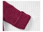 Pull rouge foncé sur un tissu en tricot blanc.