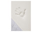 Une empreinte de main sur un matelas en mousse blanche.