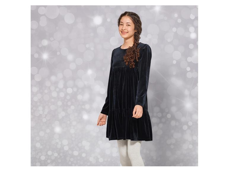 Une fille portant une robe en velours noir avec un legging gris.