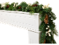 Guirlande de Noël avec pommes de pin et baies blanches sur une cheminée blanche