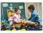 Deux enfants jouent avec des blocs LEGO colorés sur un tapis.
