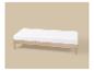 Lit de jour en bois clair avec matelas blanc sur fond beige.