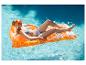 Femme en bikini flottant sur un matelas gonflable orange dans une piscine.