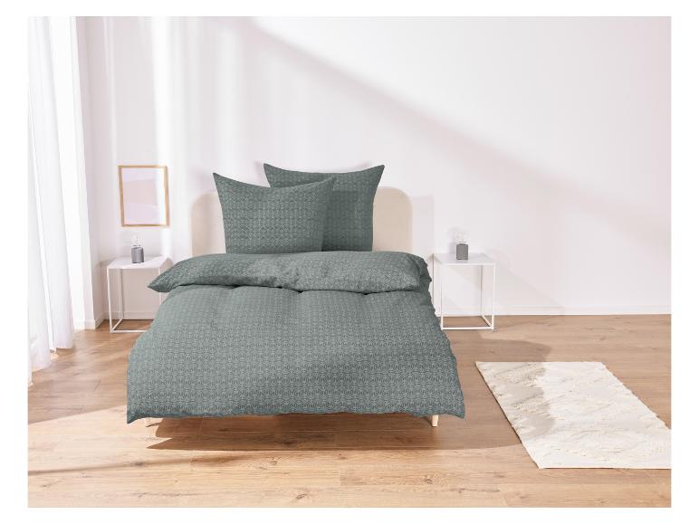 Une parure de lit vert foncé avec un motif géométrique.